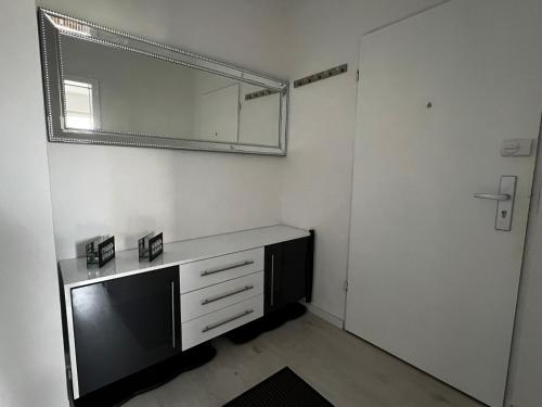 um quarto branco com um espelho e uma cómoda em Best Apartment Augsburg em Augsburg