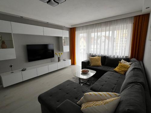 a living room with a couch and a tv at Best Apartment Augsburg in Augsburg