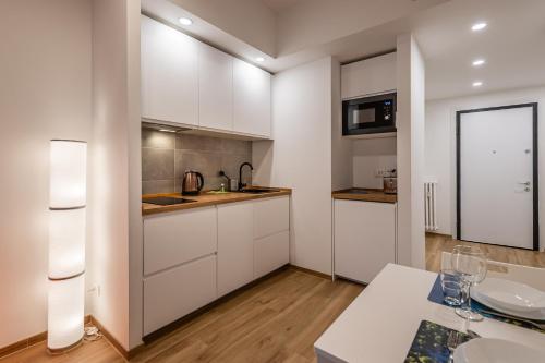 una cucina con mobili bianchi e un lavandino di CASA SIMONA Comfort moderno in ottima posizione a Rapallo