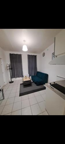 een woonkamer met een blauwe bank in een keuken bij Charmant studio en plein centre ville et 3 minutes de la gare in Saint-Quentin