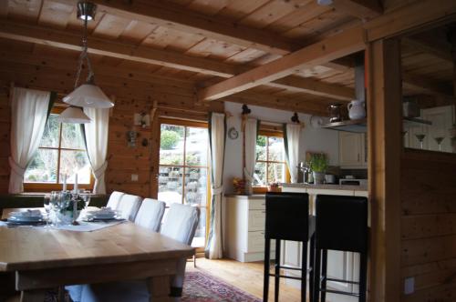 una cucina e una sala da pranzo con tavolo e sedie in legno di Chalet Steiermark a Pusterwald