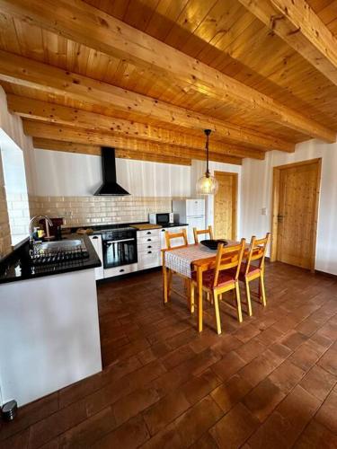 a kitchen with a table and chairs in a room at Monte da Caniveta - Casa do Avô in São Luis