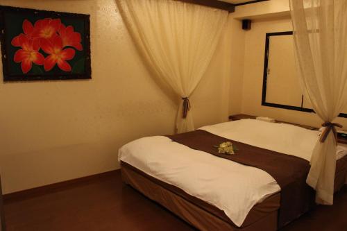 Un dormitorio con una cama con flores. en Ciao-LoveHotel, en Miyazaki