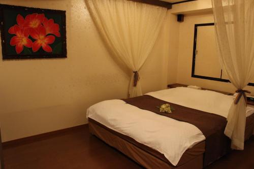 een slaapkamer met een bed met bloemen erop bij Ciao-LoveHotel in Miyazaki