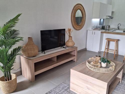 a living room with a flat screen tv on a table at Simbithi Golf Estate Luxury Apartment in Ballito