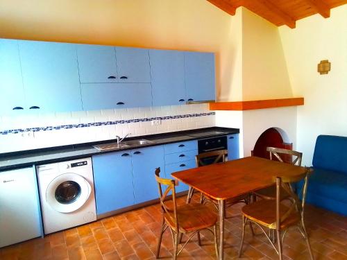 uma cozinha com uma mesa e uma máquina de lavar roupa em VALE DE GAIOS - CASARÃO by Stay in Alentejo em São Luis