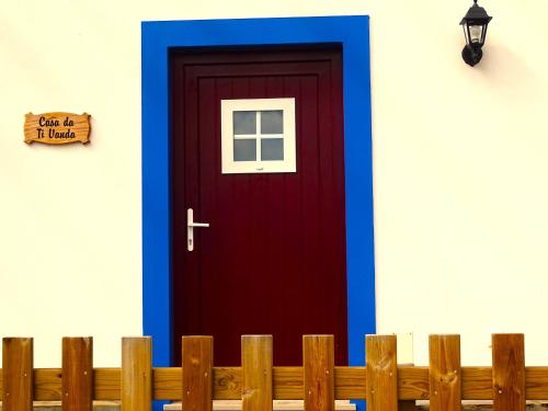 a red door with blue trim next to a fence at VALE DE GAIOS - CASARÃO by Stay in Alentejo in São Luis