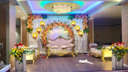 een kamer met een grote boog met een bank en bloemen bij THE SKYLITE HOTEL & BANQUET in Ara
