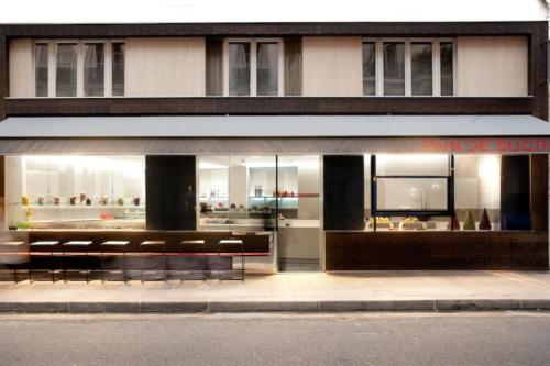 un front de magasin avec bancs devant un bâtiment dans l'établissement Joli studio Paris Le Marais - 1'min Rambuteau Station, à Paris