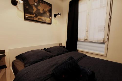 une chambre avec un lit et une fenêtre dans l'établissement Joli studio Paris Le Marais - 1'min Rambuteau Station, à Paris
