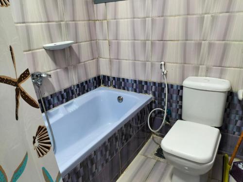 a bathroom with a toilet and a bath tub at Flores casas de playa in Alexandria