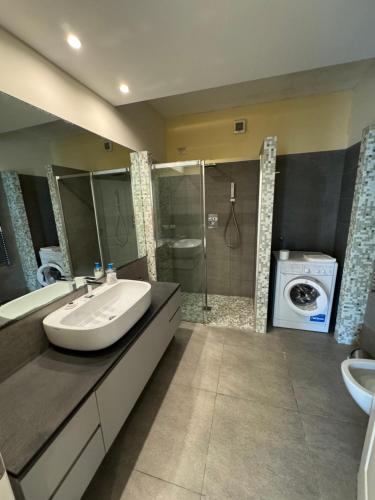 a bathroom with a sink and a washing machine at Appartamenti Michela in Camogli