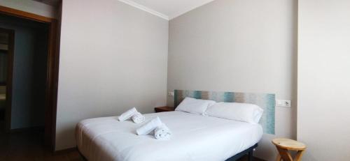 1 dormitorio con 1 cama blanca y 2 almohadas en Apartamento El Prado, en Ondara