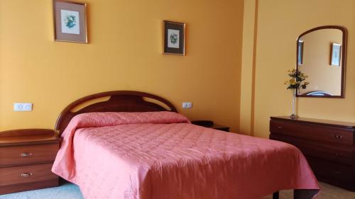 - une chambre avec un lit, une commode et un miroir dans l'établissement Amplio piso en Pontedeume, à Pontedeume
