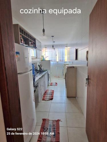 uma cozinha com um frigorífico branco e piso em azulejo em Apartamento em Cabo Frio