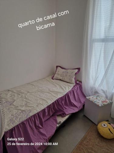 uma pequena cama num quarto com uma janela em Apartamento em Cabo Frio