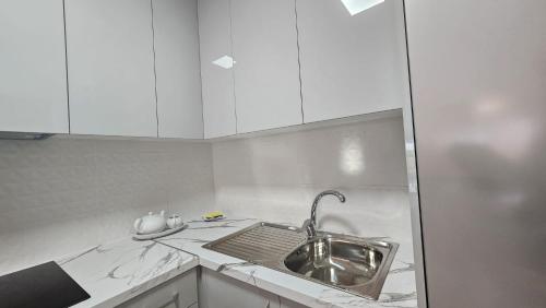 a kitchen with a sink and white cabinets at Residencial Chayofa, 1 dormitorio in Chayofa