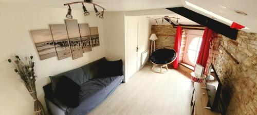 a room with a bed and a stone wall at Appartement de Charme - Centre Ville in Châteaubriant