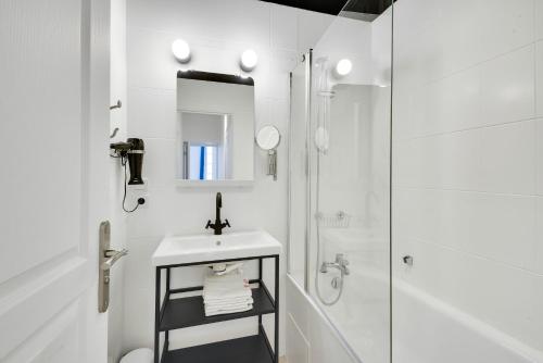 une salle de bain blanche avec un lavabo et une douche dans l'établissement Appartements hyper-centre de Marseille, à Marseille