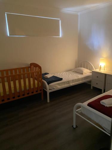 a small bedroom with two beds and a table at The Happy Delightful Place - Entire 2 Room Apartment in Cockburn Central