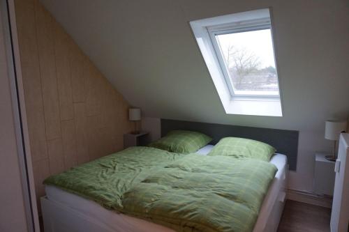 ein Schlafzimmer mit einem Bett und einem Fenster darauf in der Unterkunft Vinnenhus Wohnung 06 in Cuxhaven
