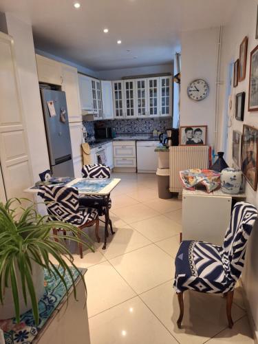 - une cuisine avec des chaises en noir et blanc et une table dans l'établissement Appartement de charme pres de Montmartre, à Paris