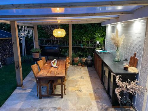 d'une terrasse avec une table en bois et un comptoir. dans l'établissement DD HOME près PARIS, à Viarmes