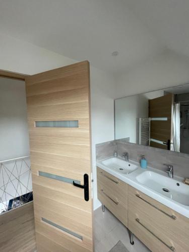 a bathroom with a door with a sink and a mirror at DD HOME près PARIS in Viarmes