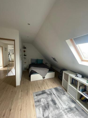 une chambre avec un lit dans un grenier dans l'établissement DD HOME près PARIS, à Viarmes