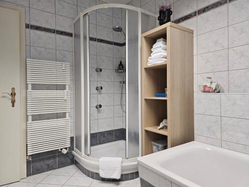 een badkamer met een douche en een wit bad bij Lueg36 am See in Sankt Gilgen