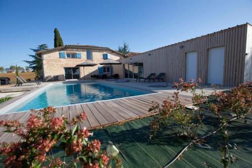 uma casa com uma piscina e um deque de madeira em Villa Virginie gite 2 
