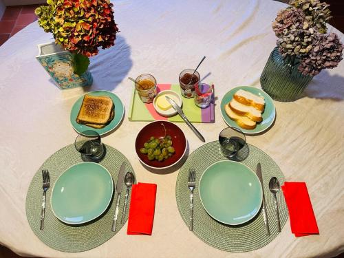 a table with plates of food on top of it at Chambres de charme avec jardin et piscine in Coulonges-sur-lʼAutize