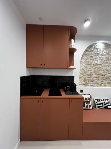 - une cuisine avec des placards bruns et une cuisinière dans l'établissement The Studio Family - Le Terracotta, à Dijon
