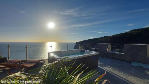 uma banheira sentada no topo de uma varanda com o oceano em Castelo do Mar, Madeira em Tábua