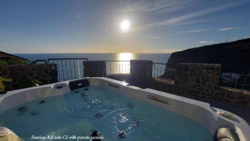 bañera de hidromasaje en un balcón con vistas al océano en el fondo en Castelo do Mar, Madeira en Tábua