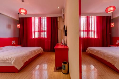 a red room with two beds and red curtains at Happy Dragon City Center Alley Hotel -In the city center with big window&heater, ticket service&Free Coffee&Food recommendation,Near Tian Anmen Forbiddencity,Easy to get traditional Walking area&Shichahai in Beijing