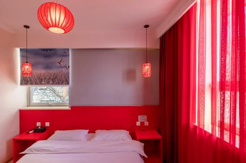 a red bedroom with a bed and two red tables at Happy Dragon City Center Alley Hotel -In the city center with big window&heater, ticket service&Free Coffee&Food recommendation,Near Tian Anmen Forbiddencity,Easy to get traditional Walking area&Shichahai in Beijing
