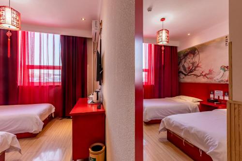 a hotel room with two beds and red curtains at Happy Dragon City Center Alley Hotel -In the city center with big window&heater, ticket service&Free Coffee&Food recommendation,Near Tian Anmen Forbiddencity,Easy to get traditional Walking area&Shichahai in Beijing