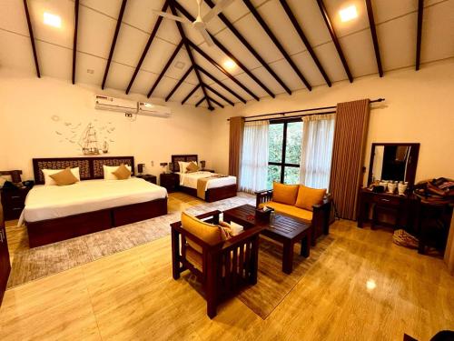 ein großes Schlafzimmer mit einem Bett und ein Wohnzimmer in der Unterkunft Sigiriya Cashew Palace Resort in Daganapothaha