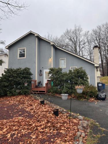 a gray house with trees in front of it at Home sweet home in woods in Tobyhanna