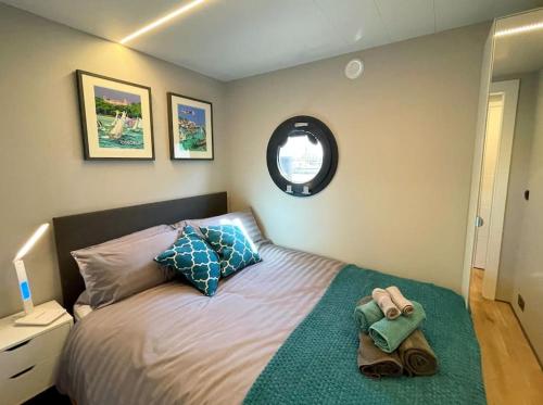 a bedroom with a bed with a green blanket at Yarmouth Waterlodge Floating Apartments 2 in Yarmouth