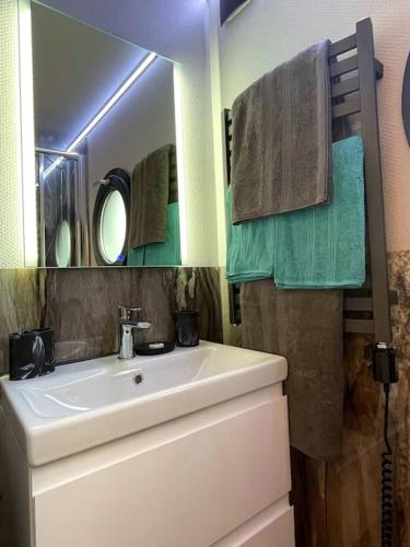 a bathroom with a sink and a mirror at Yarmouth Waterlodge Floating Apartments 2 in Yarmouth
