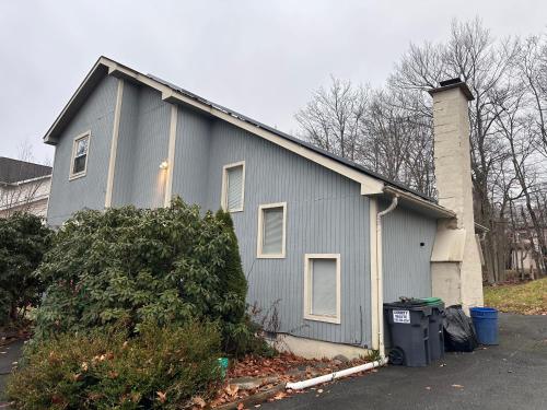 a gray house with a garage and a trash can at Home sweet home in woods in Tobyhanna