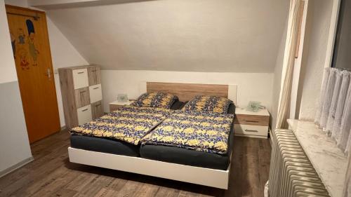 um pequeno quarto com uma cama e uma mesa de cabeceira em FeWo-Busche, Doppelhaushälfte mit Garten em Wittmund