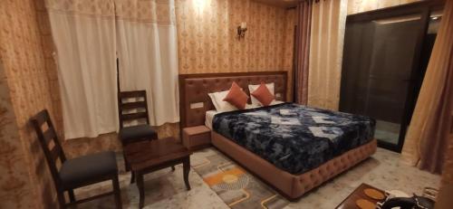 een slaapkamer met een bed, een bureau en een stoel bij Pomme Homestay in Kasauli