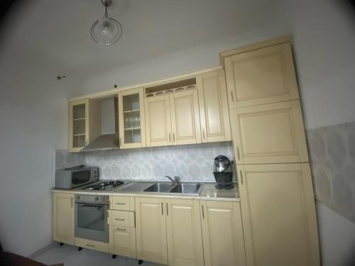 een keuken met witte kasten en een wastafel bij Tota apartments in Shkodër