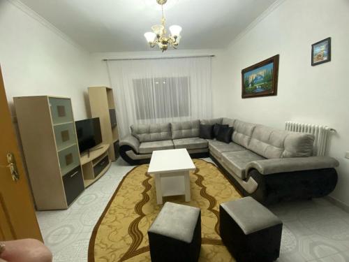 een woonkamer met een bank en een tafel bij Tota apartments in Shkodër