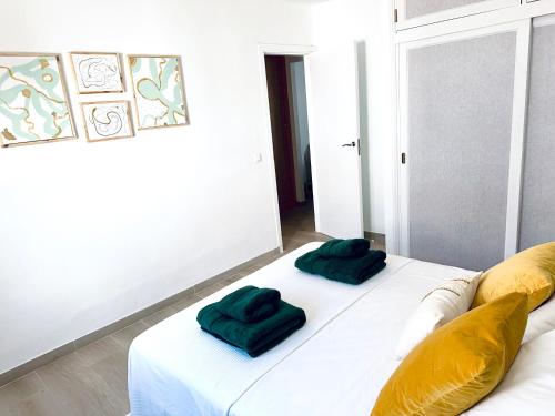 a white couch with two green pillows on it at Hope house Lanzarote in Puerto del Carmen