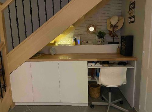 un bureau sous les escaliers avec un bureau en dessous dans l'établissement Maison à 10 min à pieds du RER Bourg la reine, à Bourg-la-Reine