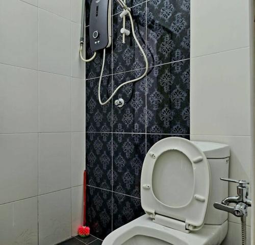 een badkamer met een toilet en een telefoon aan de muur bij 42 Klebang - KKS Plus Collection in Ipoh